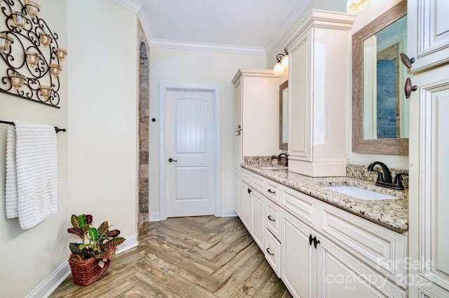 bathroom with crown molding, double vanity, baseboards, and a sink