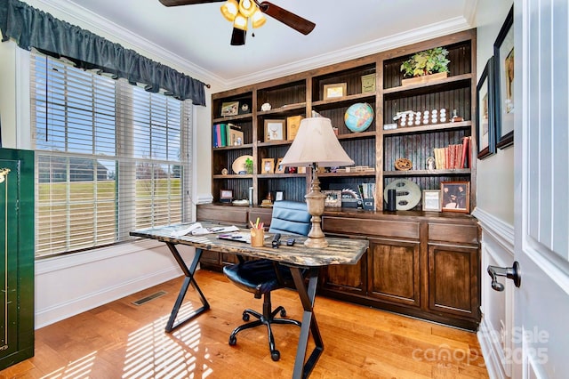 office space featuring a ceiling fan, visible vents, light wood finished floors, baseboards, and crown molding