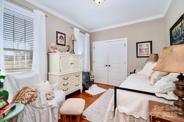 bedroom featuring a closet, crown molding, and wood finished floors