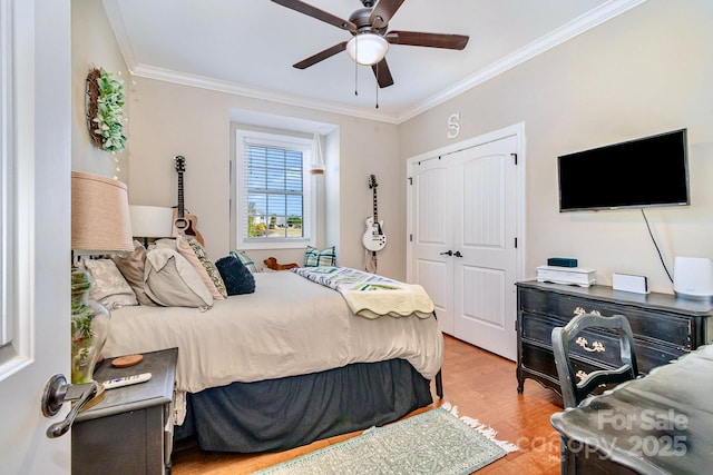 bedroom featuring a closet, crown molding, ceiling fan, and wood finished floors