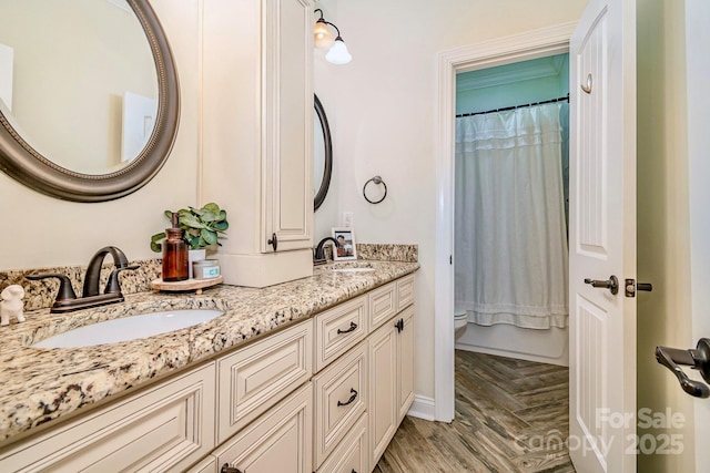 full bath with double vanity, parquet floors, toilet, and a sink