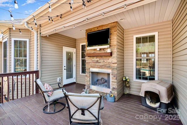 deck featuring an outdoor stone fireplace