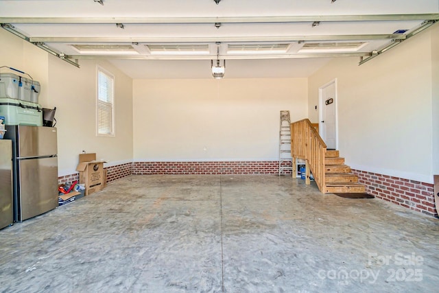 garage with a garage door opener and freestanding refrigerator