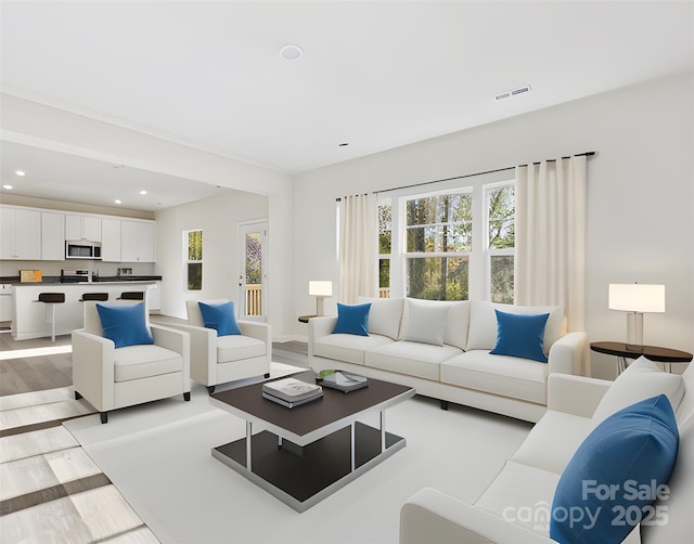 living room featuring recessed lighting, visible vents, a healthy amount of sunlight, and light wood-type flooring