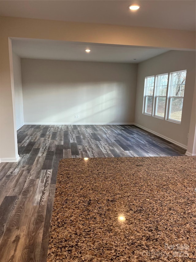 empty room with dark wood-style floors, recessed lighting, and baseboards