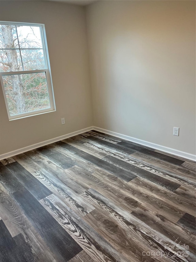 empty room with baseboards and dark wood-style flooring