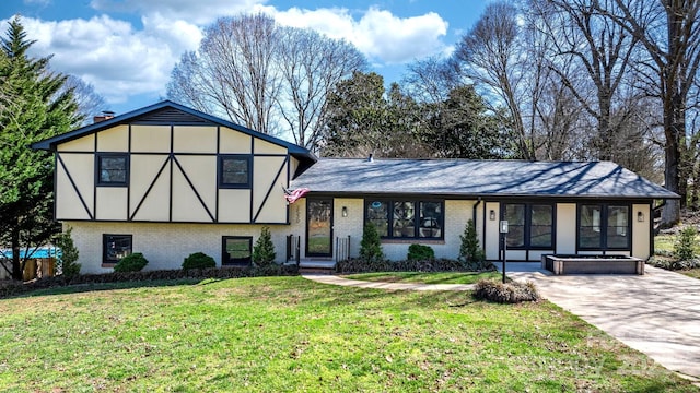 view of front of house featuring brick siding and a front lawn