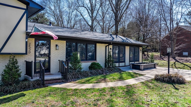 view of front of property featuring brick siding and a front lawn