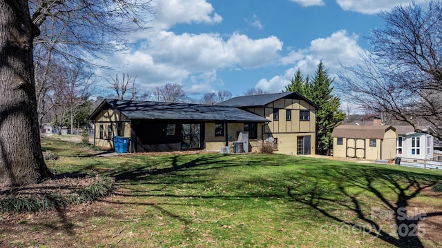 view of front of home featuring a lawn, board and batten siding, a storage unit, and an outdoor structure