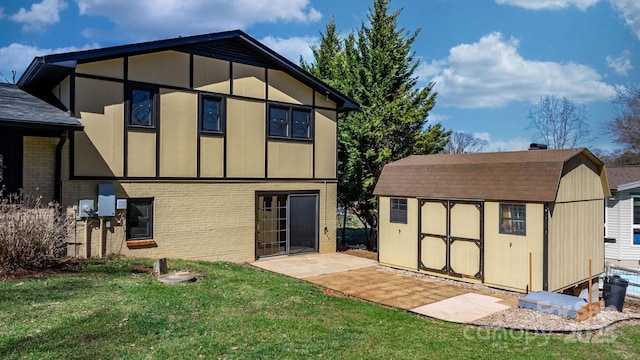 back of house featuring a yard, an outbuilding, brick siding, and a shed