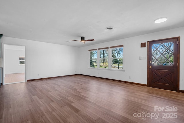 foyer featuring visible vents, a ceiling fan, baseboards, and wood finished floors