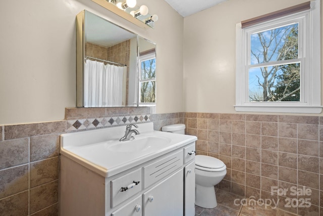 bathroom with vanity, tile walls, toilet, and tile patterned flooring