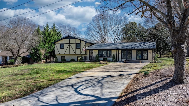 split level home featuring stucco siding, driveway, and a front yard