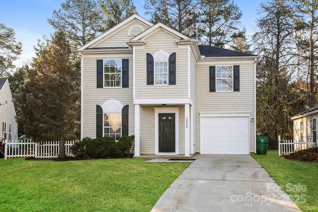 traditional-style home with a garage, driveway, a front lawn, and fence