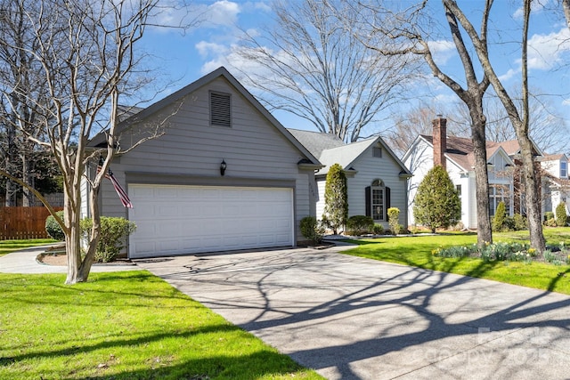 view of front facade with driveway, a front lawn, an attached garage, and fence