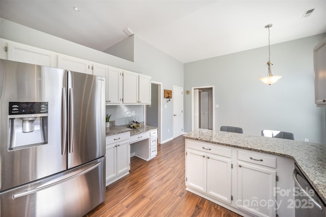 kitchen featuring stainless steel appliances, wood finished floors, white cabinets, built in desk, and decorative light fixtures