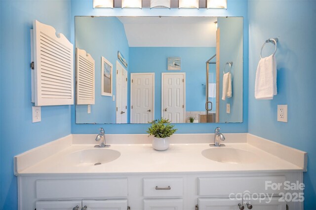 full bath featuring double vanity, a shower stall, and a sink