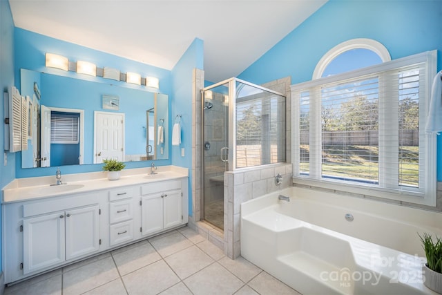 full bath with a bath, double vanity, a sink, and tile patterned floors