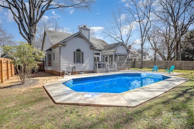 view of swimming pool with a lawn, a fenced in pool, a patio, a sunroom, and a fenced backyard