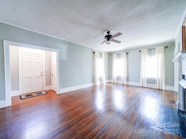 unfurnished living room with baseboards, a fireplace with flush hearth, a ceiling fan, and wood finished floors