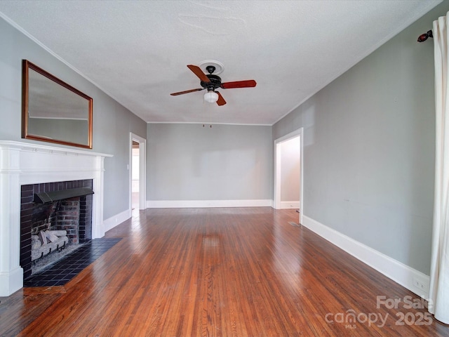 unfurnished living room featuring a fireplace, baseboards, and wood finished floors