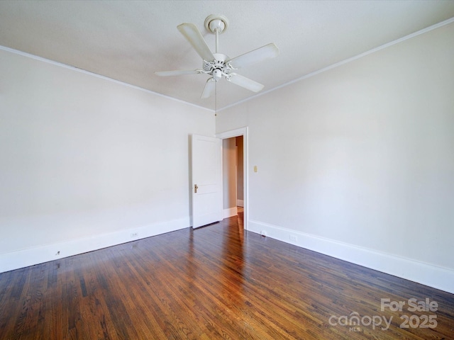 empty room featuring baseboards, ceiling fan, dark wood-type flooring, and crown molding