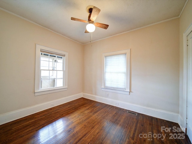 unfurnished room featuring crown molding, visible vents, baseboards, and dark wood-type flooring