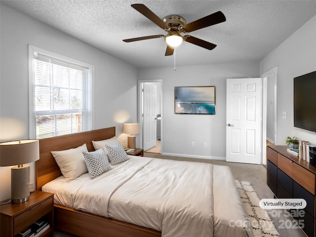 carpeted bedroom with ceiling fan, a textured ceiling, and baseboards