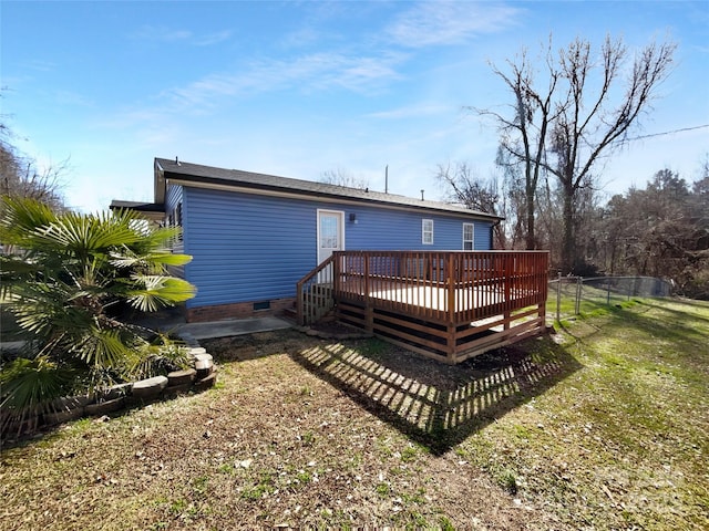 rear view of property with a deck, a yard, crawl space, and fence