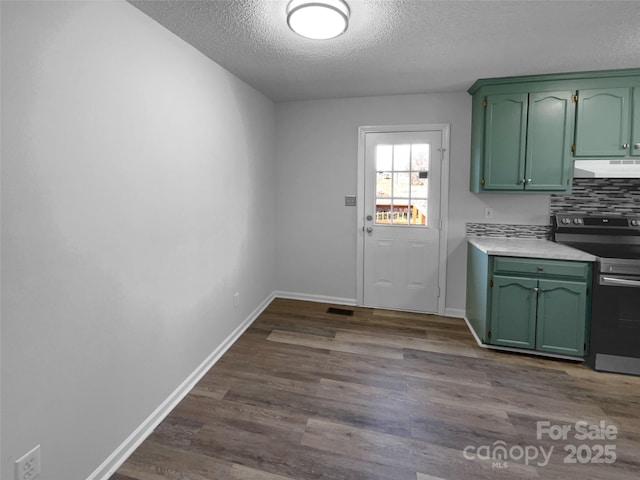 interior space featuring decorative backsplash, electric stove, dark wood-style flooring, under cabinet range hood, and green cabinetry