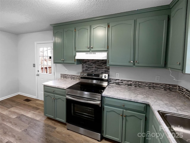 kitchen with stainless steel range with electric stovetop, range hood, dark wood finished floors, and green cabinetry