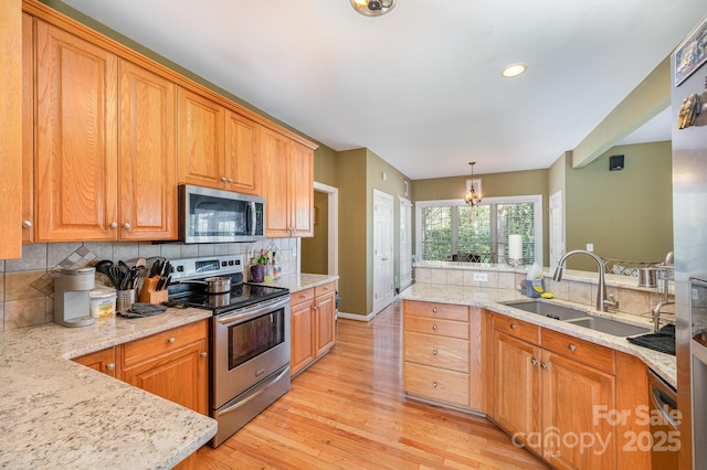 12723 Willingdon Rd, Huntersville, NC 28078 - kitchen with stainless steel appliances, tasteful backsplash, a sink, light wood-style floors, and light stone counters