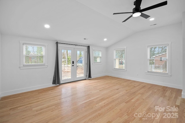 empty room with visible vents, baseboards, light wood-style flooring, vaulted ceiling, and french doors