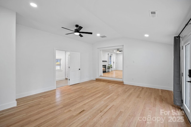 spare room with visible vents, baseboards, vaulted ceiling, recessed lighting, and light wood-style flooring