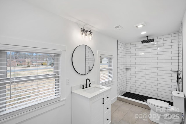 full bath featuring vanity, visible vents, tiled shower, tile patterned floors, and toilet