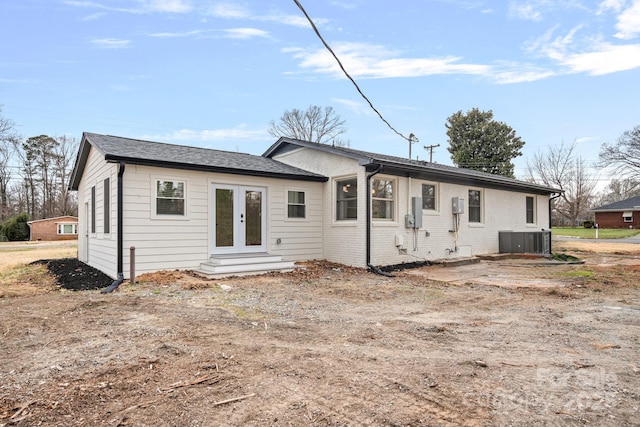 rear view of property with brick siding, central AC unit, french doors, and entry steps