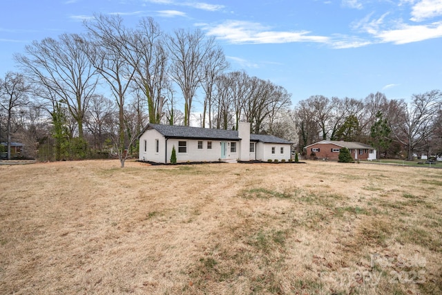 single story home featuring a front yard and a chimney