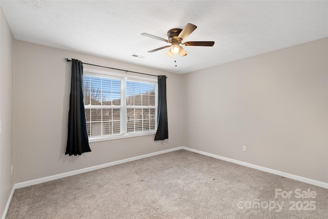 carpeted spare room featuring a textured ceiling, baseboards, and ceiling fan