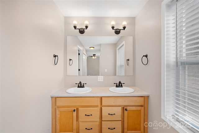 bathroom with double vanity, ceiling fan, and a sink