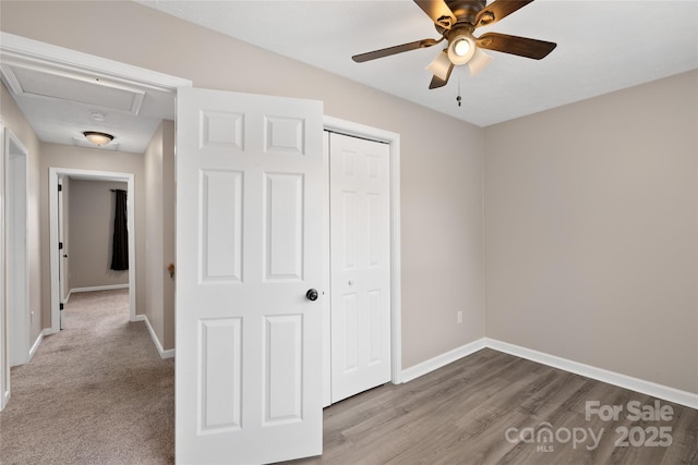 unfurnished bedroom with a closet, ceiling fan, baseboards, and wood finished floors