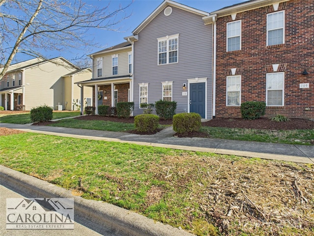 view of front of house with brick siding and a front lawn