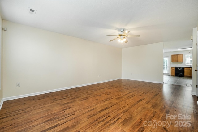 empty room with visible vents, baseboards, a ceiling fan, and hardwood / wood-style flooring