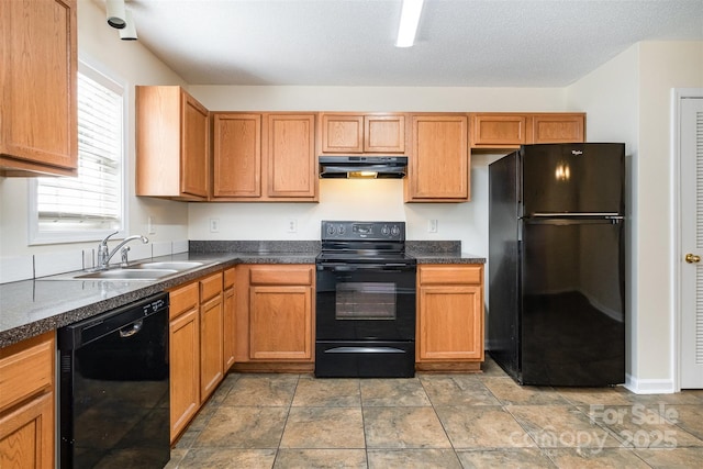 kitchen with a sink, black appliances, under cabinet range hood, a textured ceiling, and dark countertops