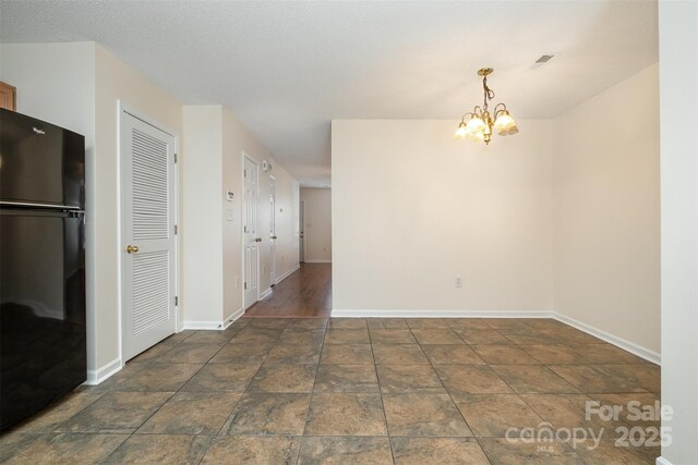 unfurnished dining area with visible vents, baseboards, and a chandelier