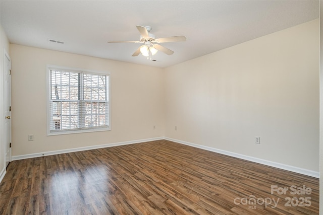 empty room featuring dark wood finished floors, visible vents, baseboards, and a ceiling fan