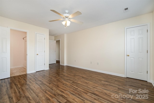 unfurnished bedroom featuring ceiling fan, visible vents, baseboards, and wood finished floors