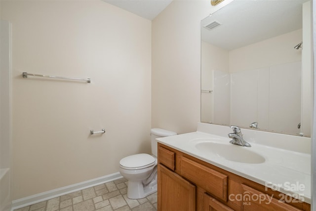 full bath featuring vanity, toilet, baseboards, and visible vents