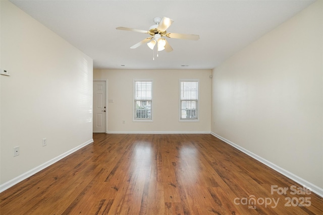 empty room featuring baseboards, ceiling fan, and wood finished floors