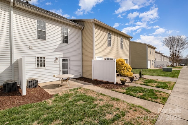 rear view of property with a yard, fence, and a patio area