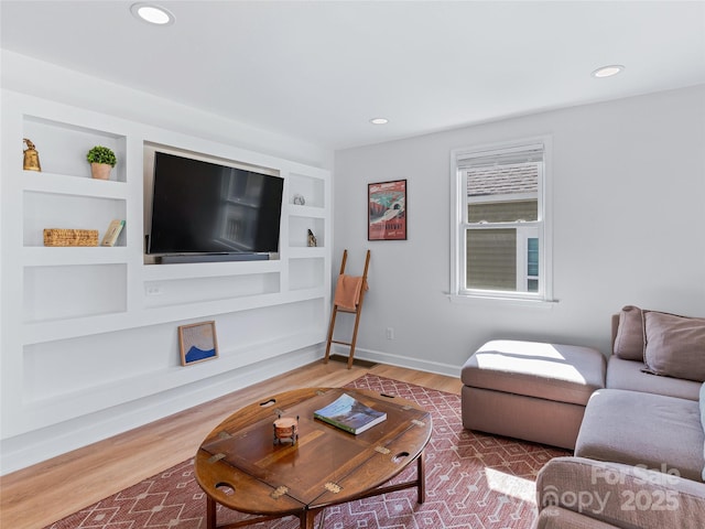 living area with recessed lighting, baseboards, built in shelves, and wood finished floors